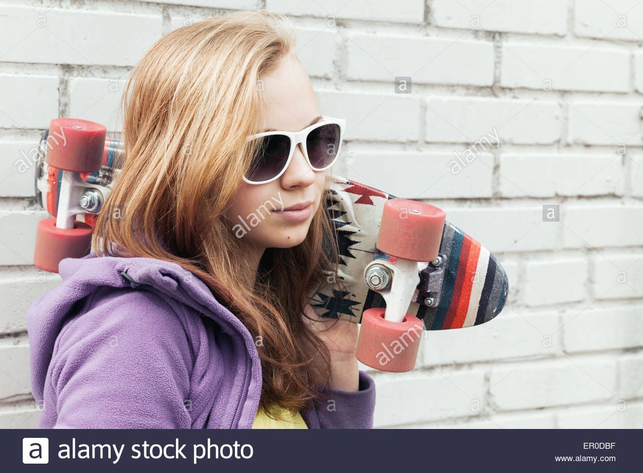 Of blond teen holding sunglasses